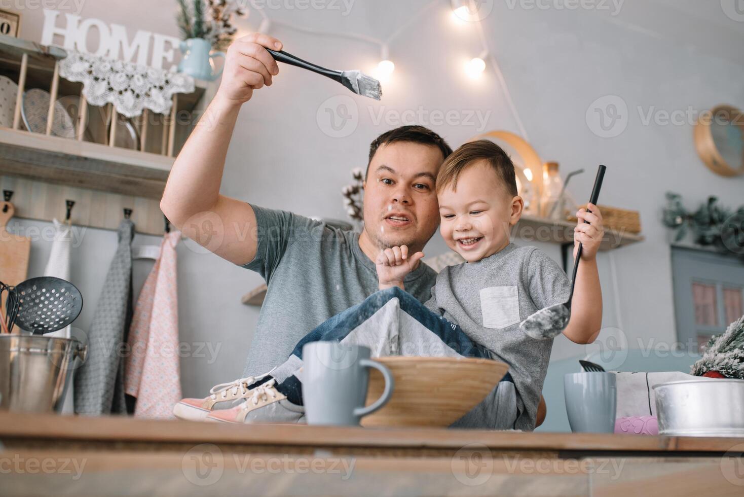 jovem homem e dele filho com forno Folha dentro cozinha. pai com pequeno filho em a cozinha. foto