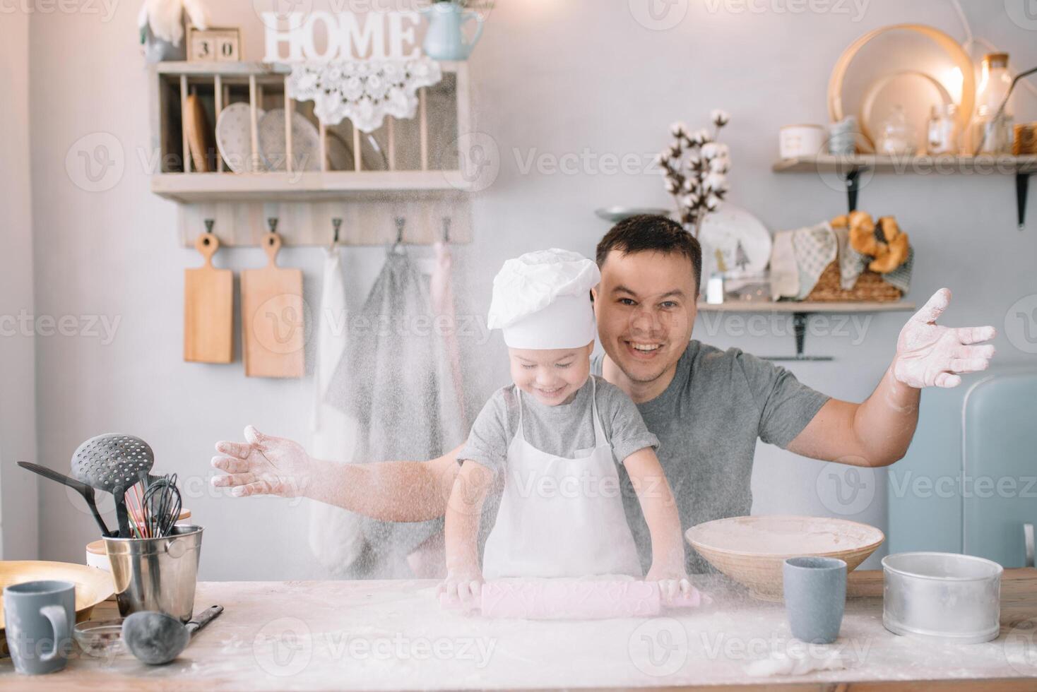 jovem homem e dele filho com forno Folha dentro cozinha. pai com pequeno filho em a cozinha. foto