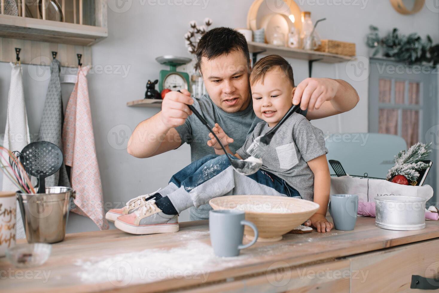 jovem homem e dele filho com forno Folha dentro cozinha. pai com pequeno filho em a cozinha. foto