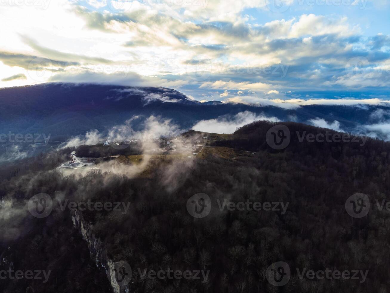 Visão do a outono Vila dentro a montanhas através a nuvens foto
