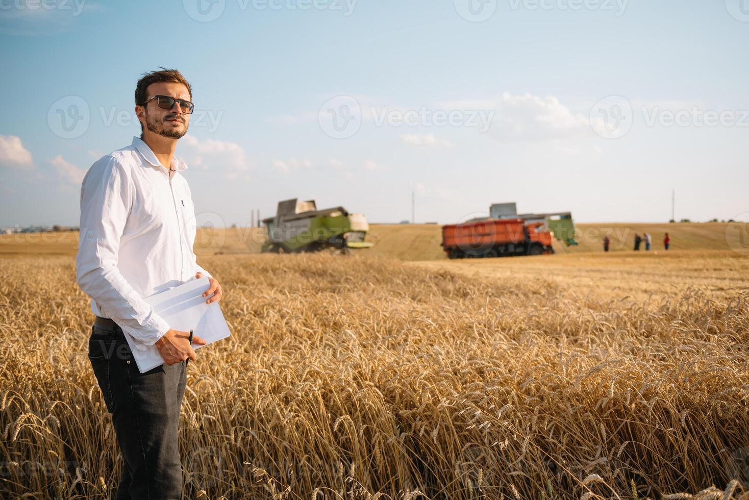 feliz agricultor dentro a campo verificação milho plantas durante uma ensolarado verão dia, agricultura e Comida Produção conceito foto