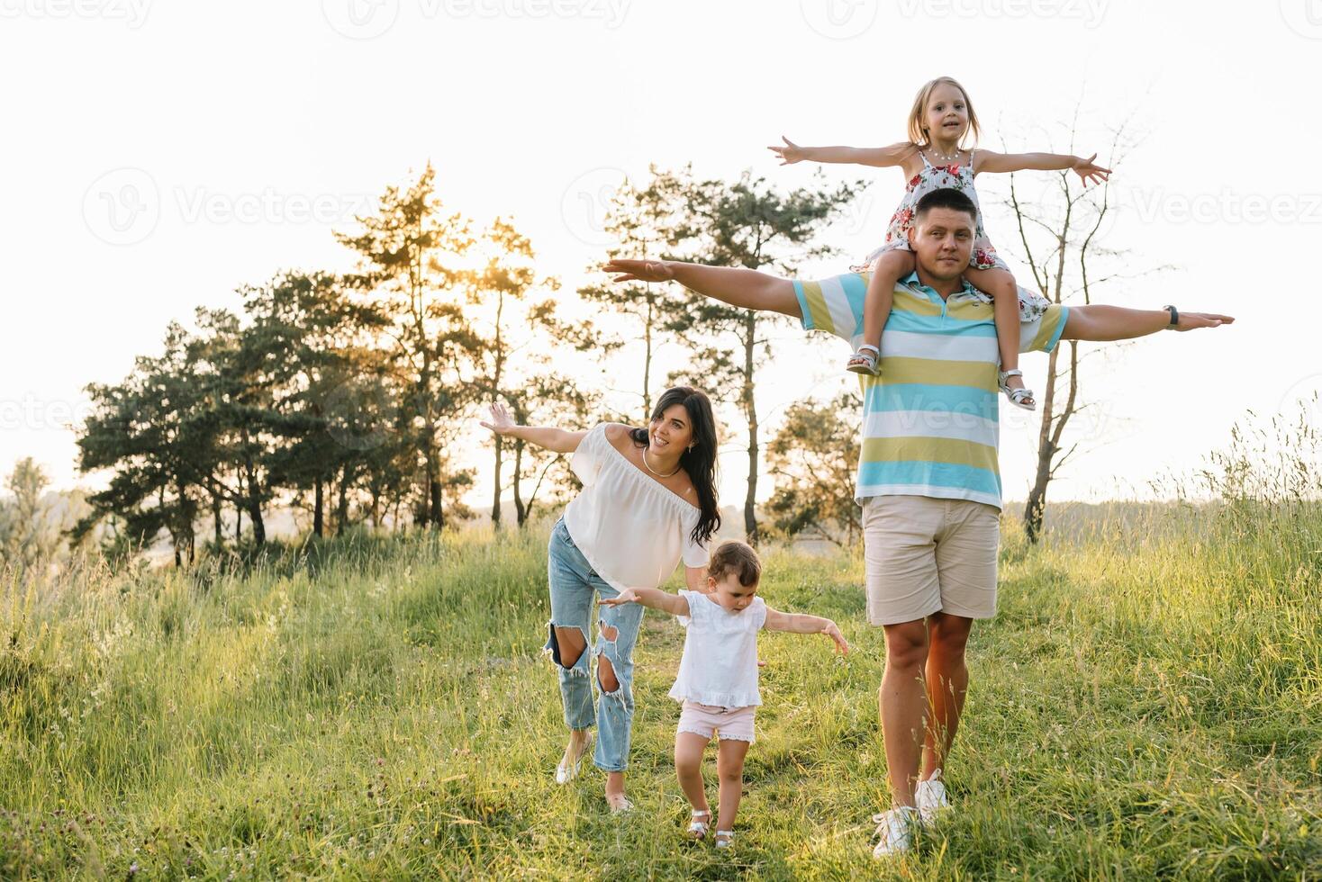 cor foto do sorridente jovem pais e dois crianças, descansar e ter Diversão dentro natureza. amor, família e feliz infância estilo de vida conceito.