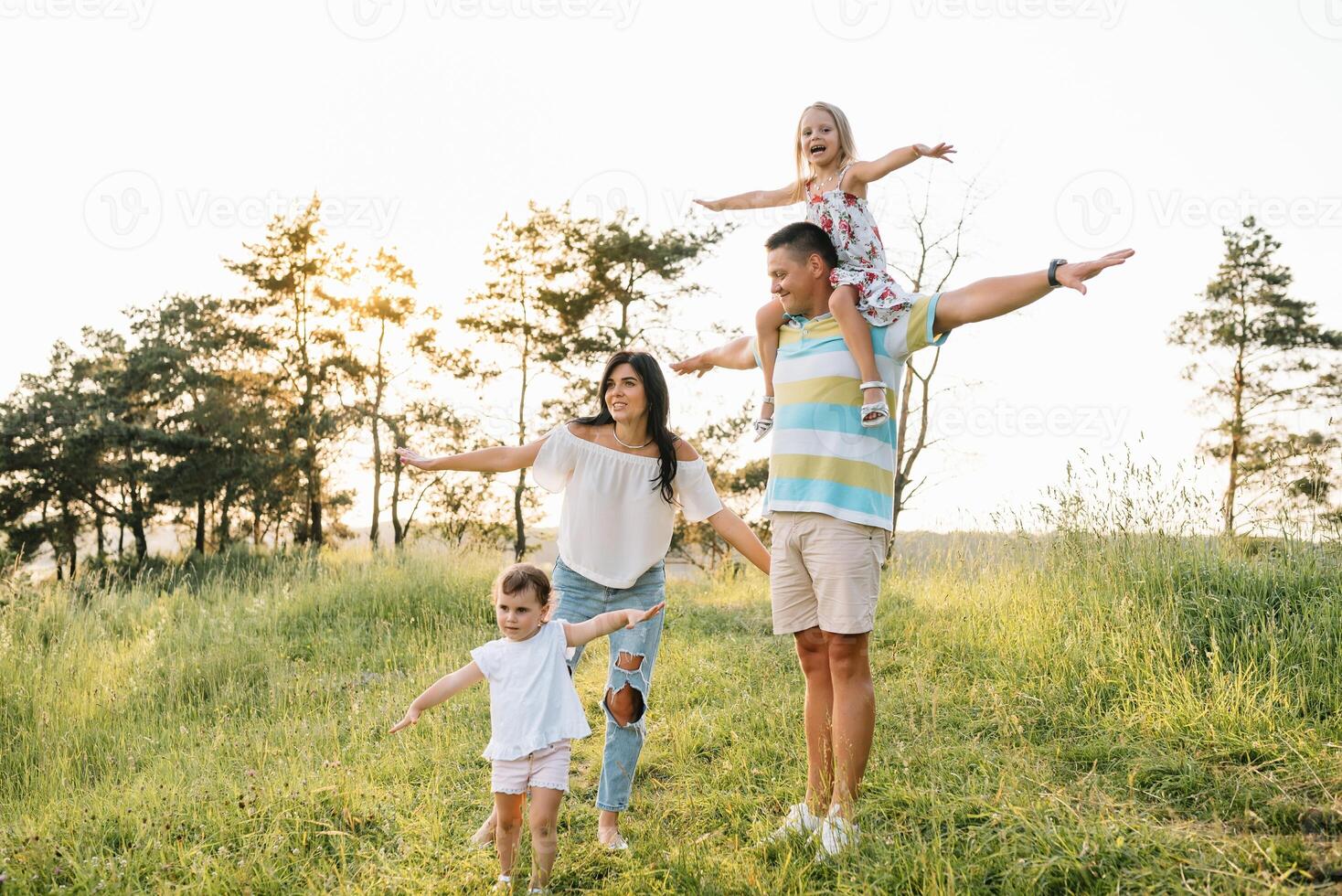cor foto do sorridente jovem pais e dois crianças, descansar e ter Diversão dentro natureza. amor, família e feliz infância estilo de vida conceito.