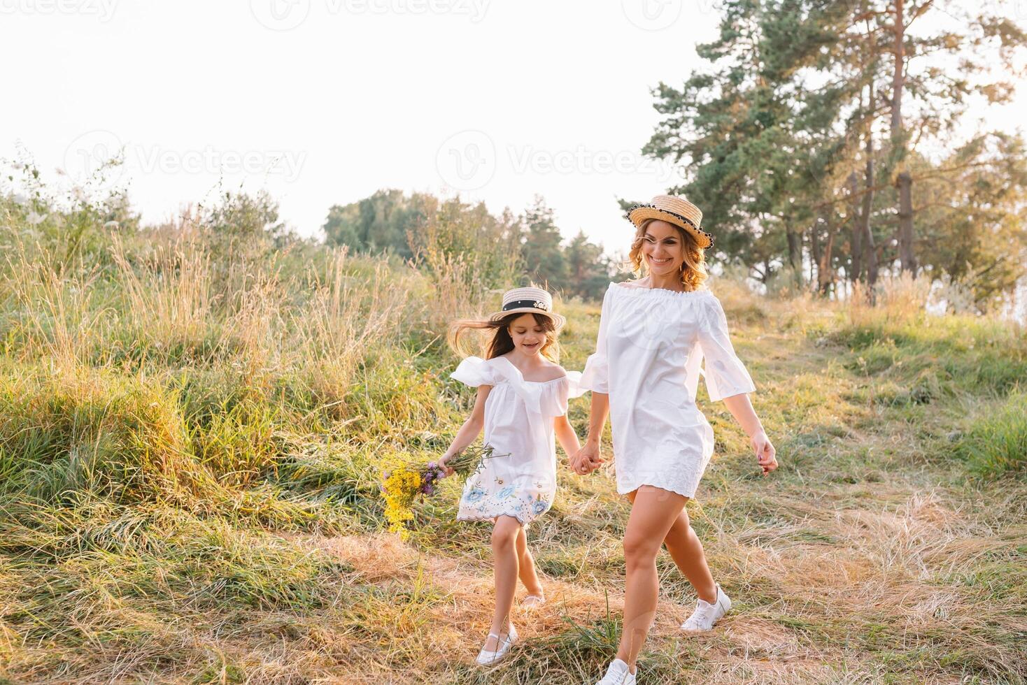 à moda mãe e bonito filha tendo Diversão em a natureza. feliz família conceito. beleza natureza cena com família ao ar livre estilo de vida. família em repouso junto. felicidade dentro família vida. mães dia. foto