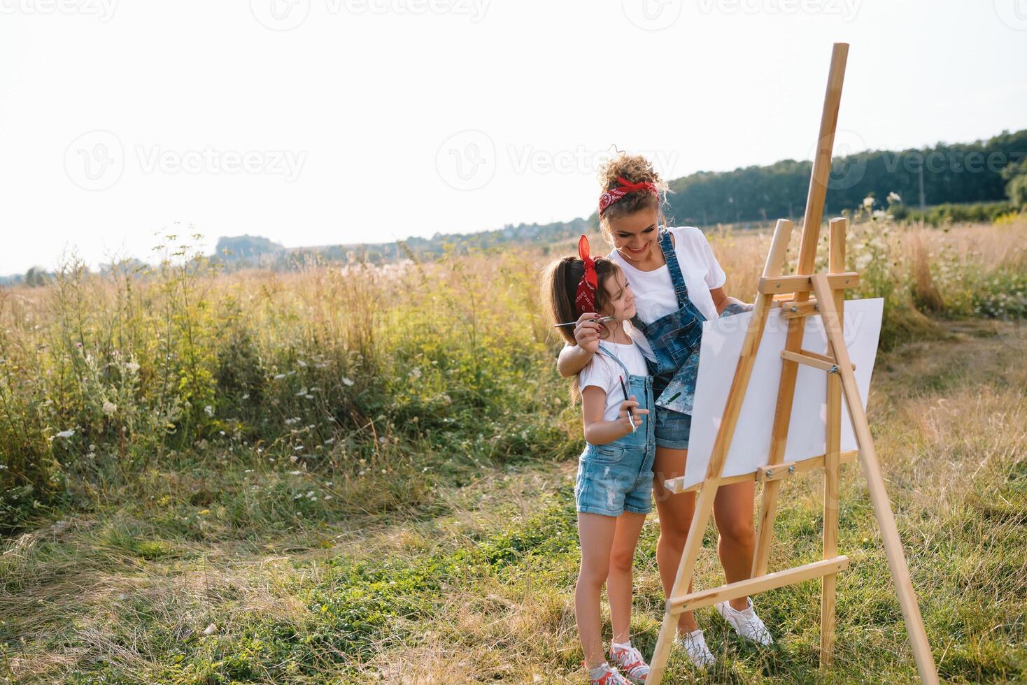 lindo mãe com filha. família dentro uma verão parque. pequeno menina desenhando foto