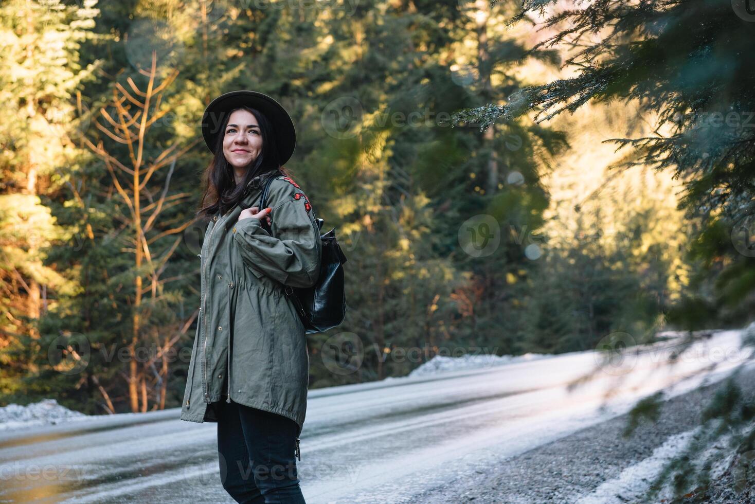 feliz menina com chapéu dentro floresta às montanha estrada fundo, relaxar Tempo em feriado conceito viagem ,cor do vintage tom e suave foco foto