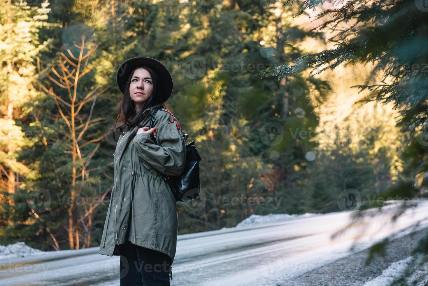 feliz menina com chapéu dentro floresta às montanha estrada fundo, relaxar Tempo em feriado conceito viagem ,cor do vintage tom e suave foco. foto