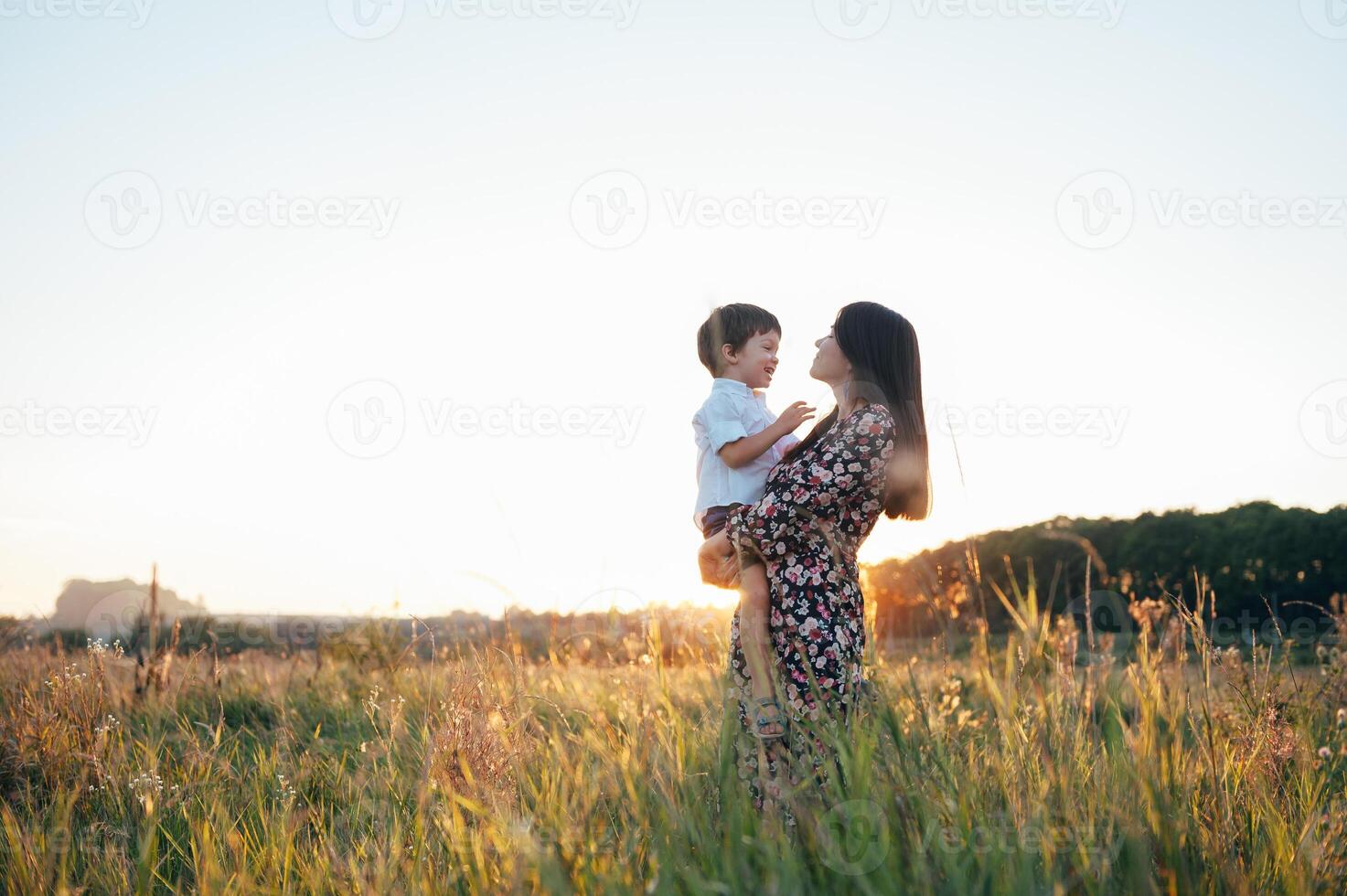 elegante mãe e bonito filho tendo Diversão em a natureza. feliz família conceito. beleza natureza cena com família ao ar livre estilo de vida. feliz família em repouso junto. felicidade dentro família vida. mães dia foto