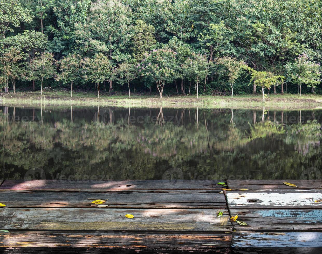 mesa de madeira vintage em frente a uma lagoa com uma paisagem de sonho e floresta abstrata foto