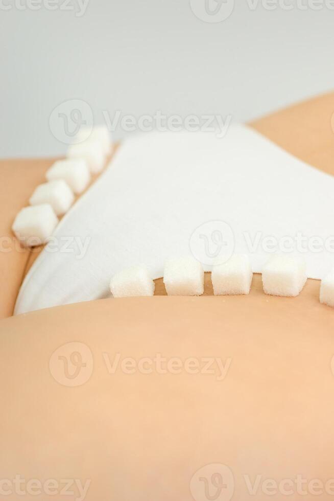 açúcar cubos deitado dentro uma linha em fêmea bikini zona, a conceito do íntimo depilação, problemas do íntimo higiene. foto