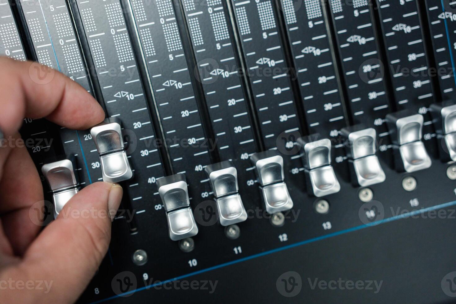 humano mão ajustando botões em audio misturador. foto