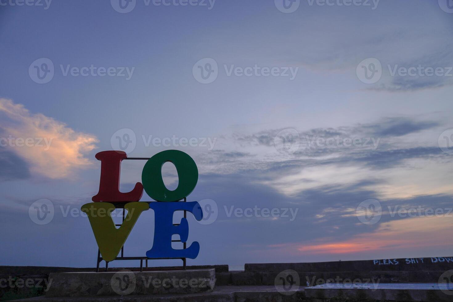 fechar-se Visão do a palavra amor colocada em a litoral contra uma pôr do sol céu com esvaziar espaço para fotocópia. foto