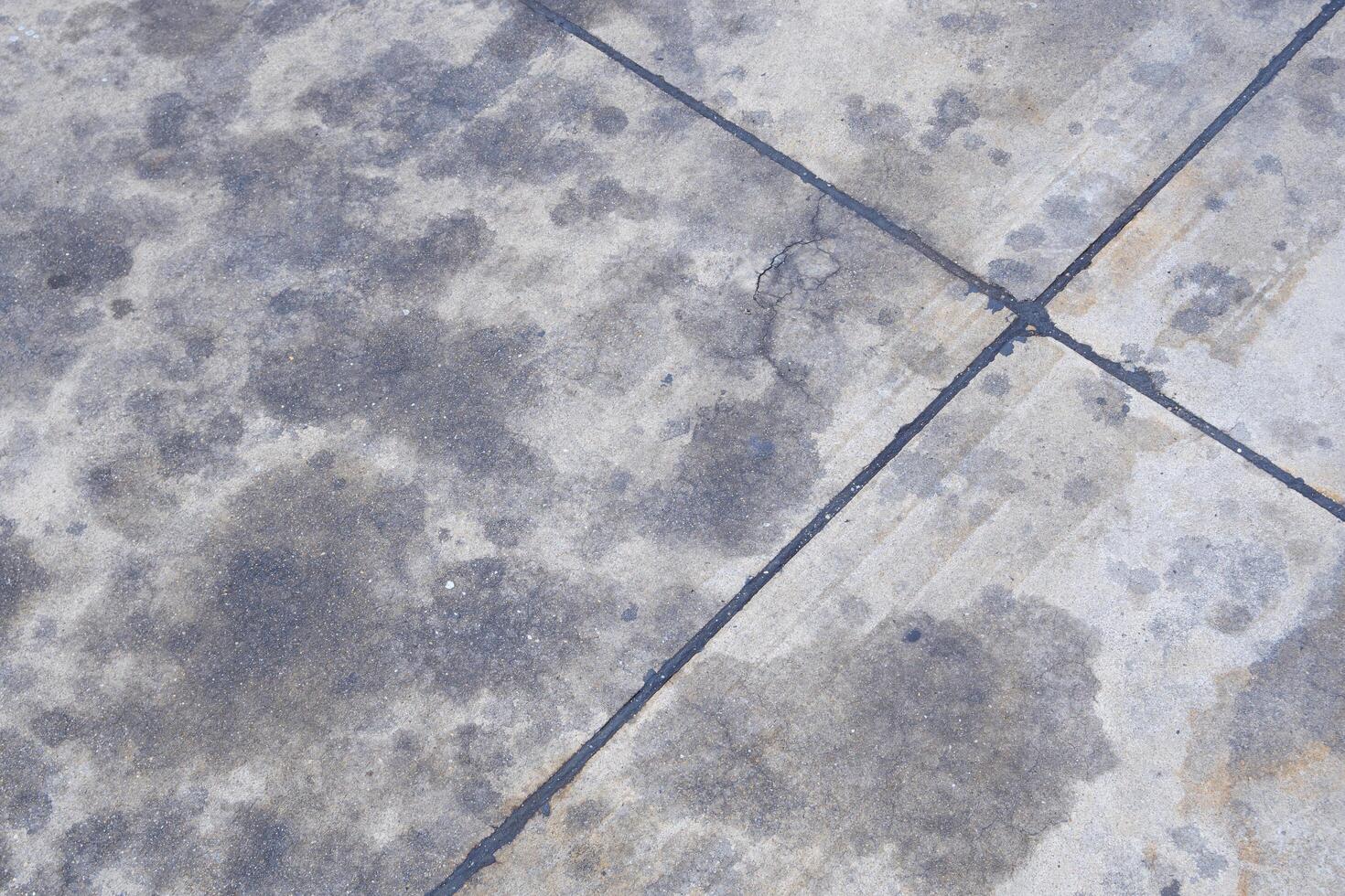 sujo concreto chão superfície com muitos carro motor óleo manchas foto
