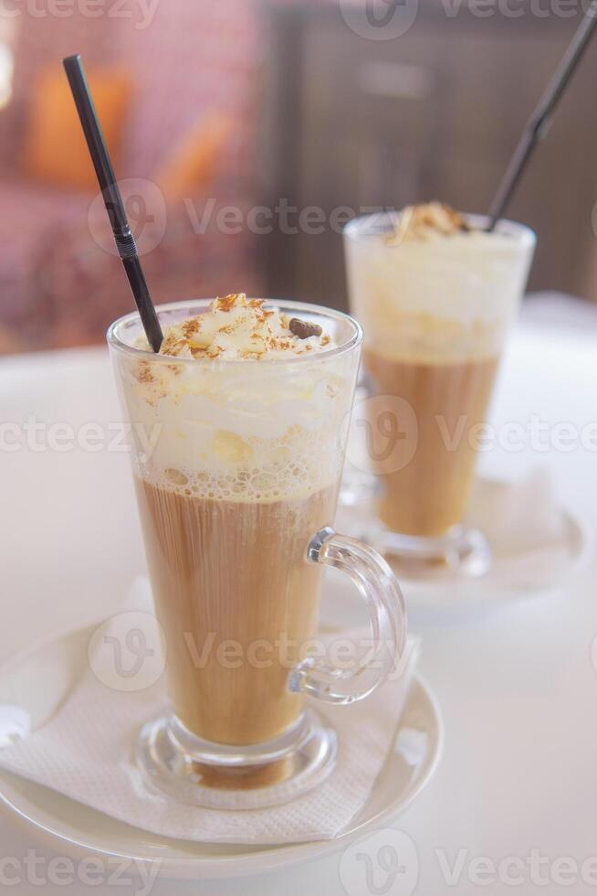 café é servido dentro uma alta vidro vidro com uma canudo. a conceito do café bebidas a partir de a Barra cardápio foto