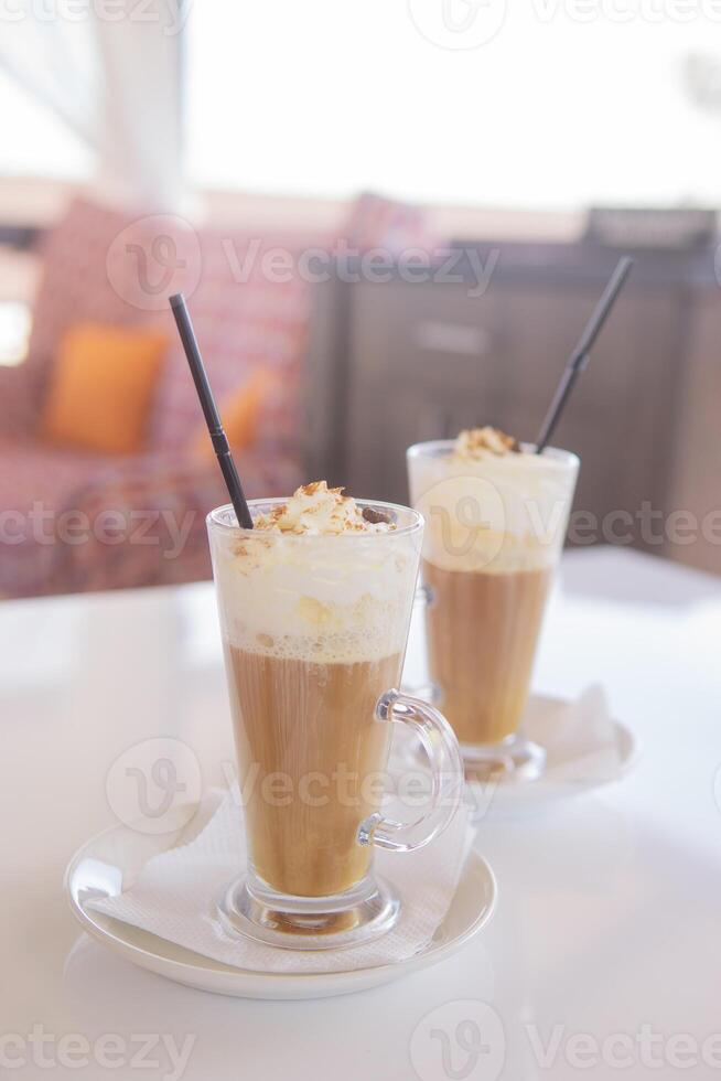 café é servido dentro uma alta vidro vidro com uma canudo. a conceito do café bebidas a partir de a Barra cardápio foto