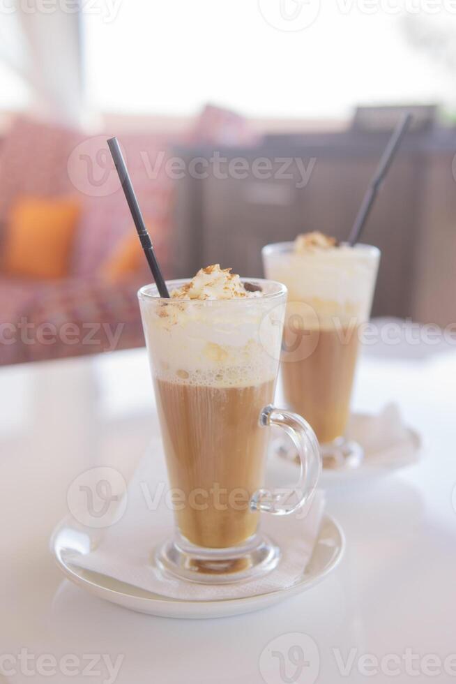 café é servido dentro uma alta vidro vidro com uma canudo. a conceito do café bebidas a partir de a Barra cardápio foto