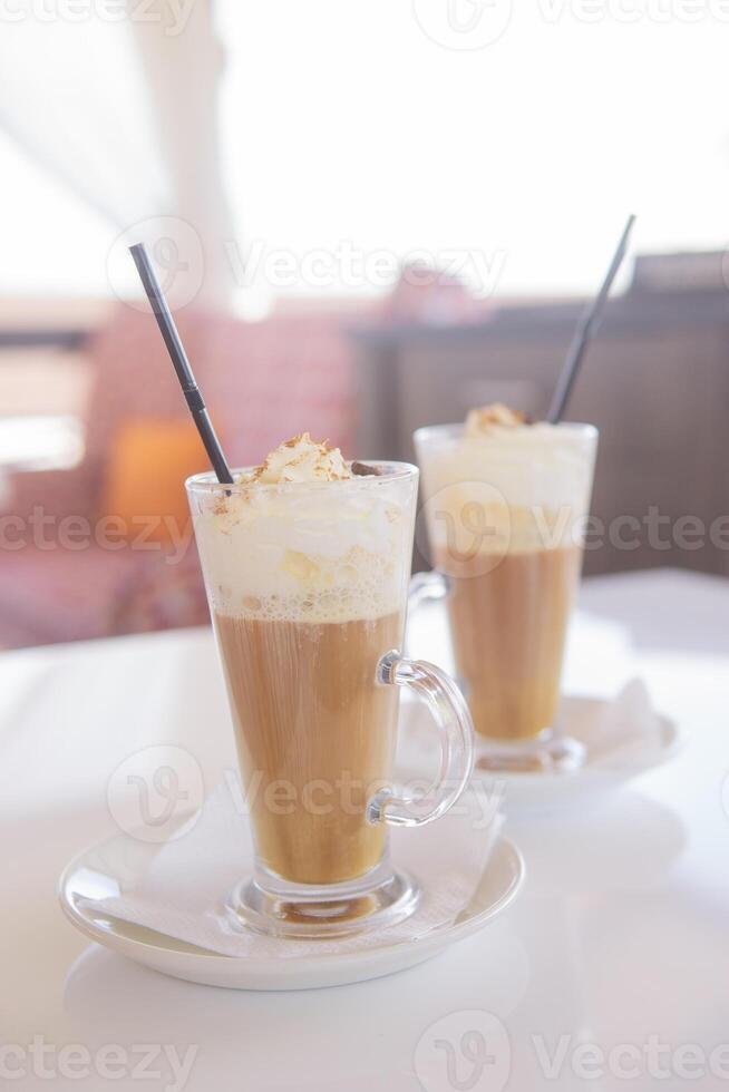 café é servido dentro uma alta vidro vidro com uma canudo. a conceito do café bebidas a partir de a Barra cardápio foto