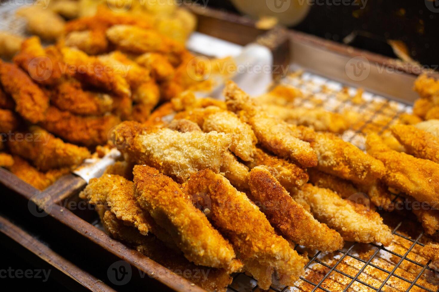 crocantes desossado frango em a em repouso bandeja pronto para vender dentro a tailandês noite mercado foto