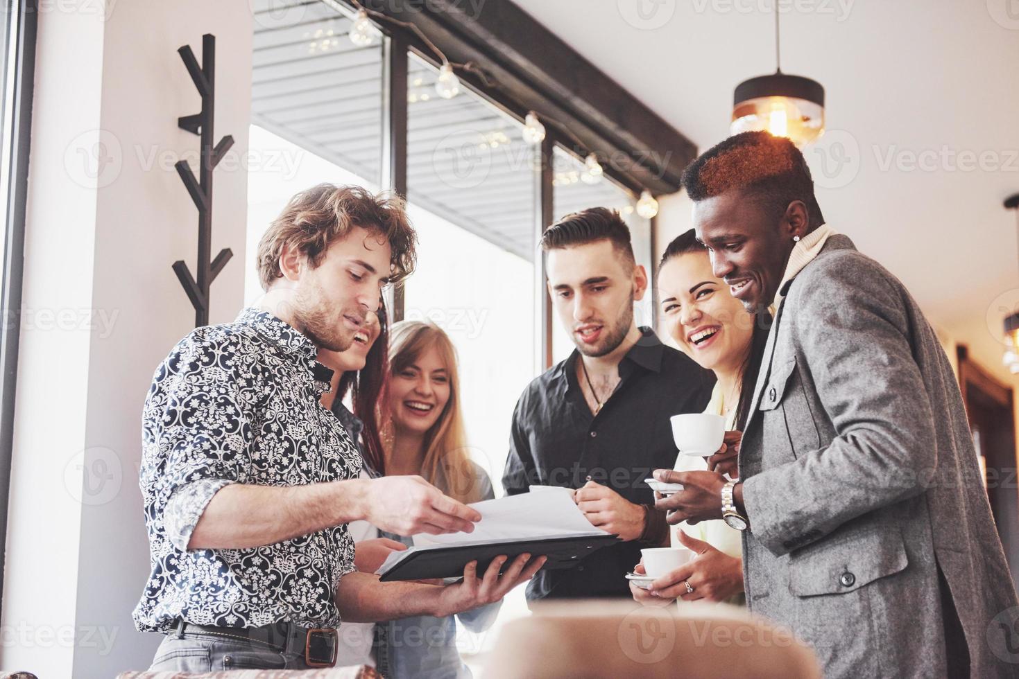 jovens empresários de sucesso estão conversando e sorrindo durante o intervalo para o café no escritório foto