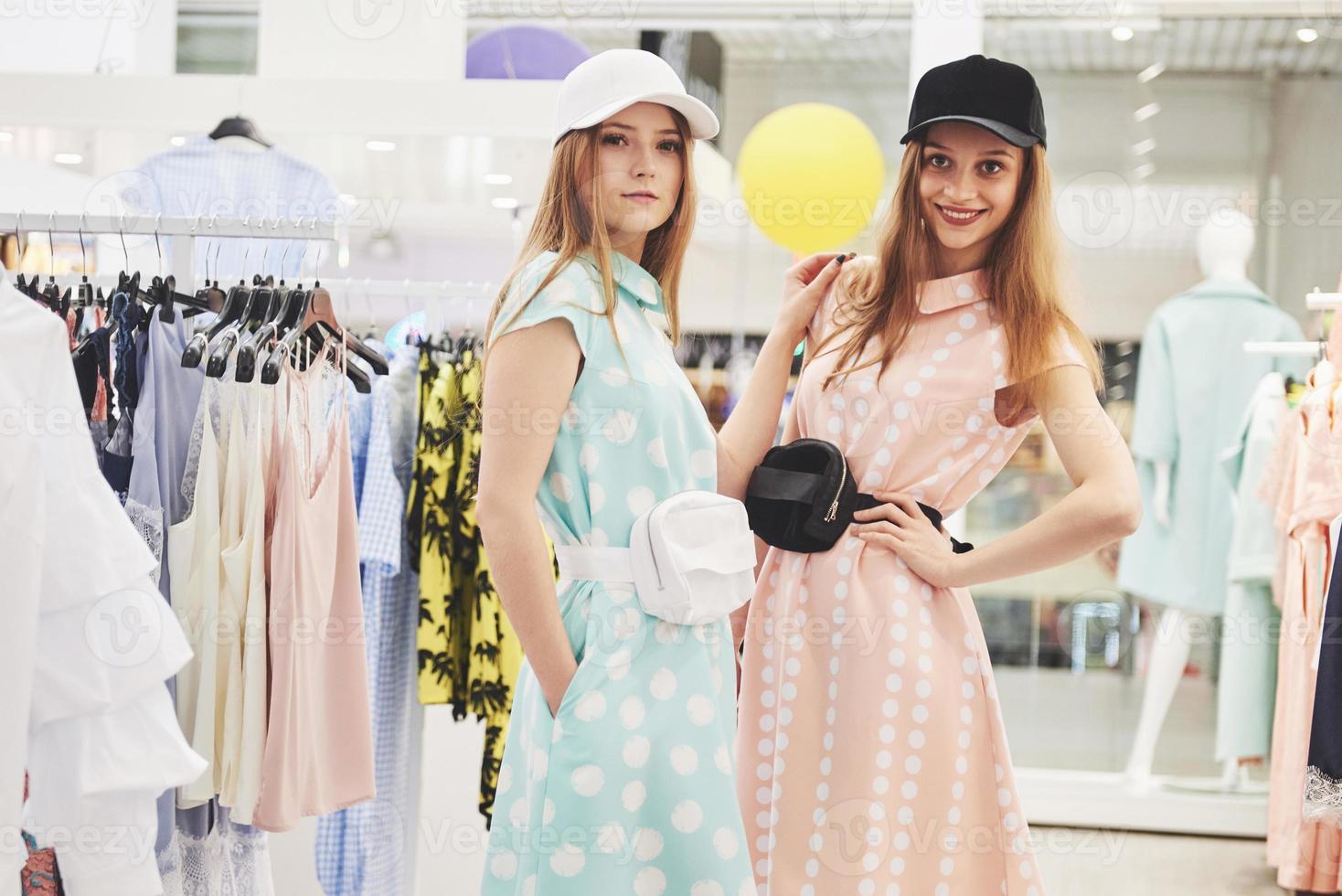 os melhores amigos passam o tempo juntos. duas lindas garotas compram na loja de roupas. eles vestiram as mesmas roupas foto