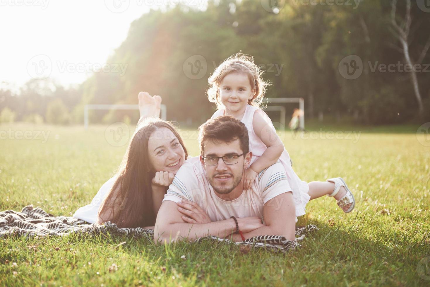 família feliz, pai de mãe e filha de bebê na natureza ao pôr do sol foto