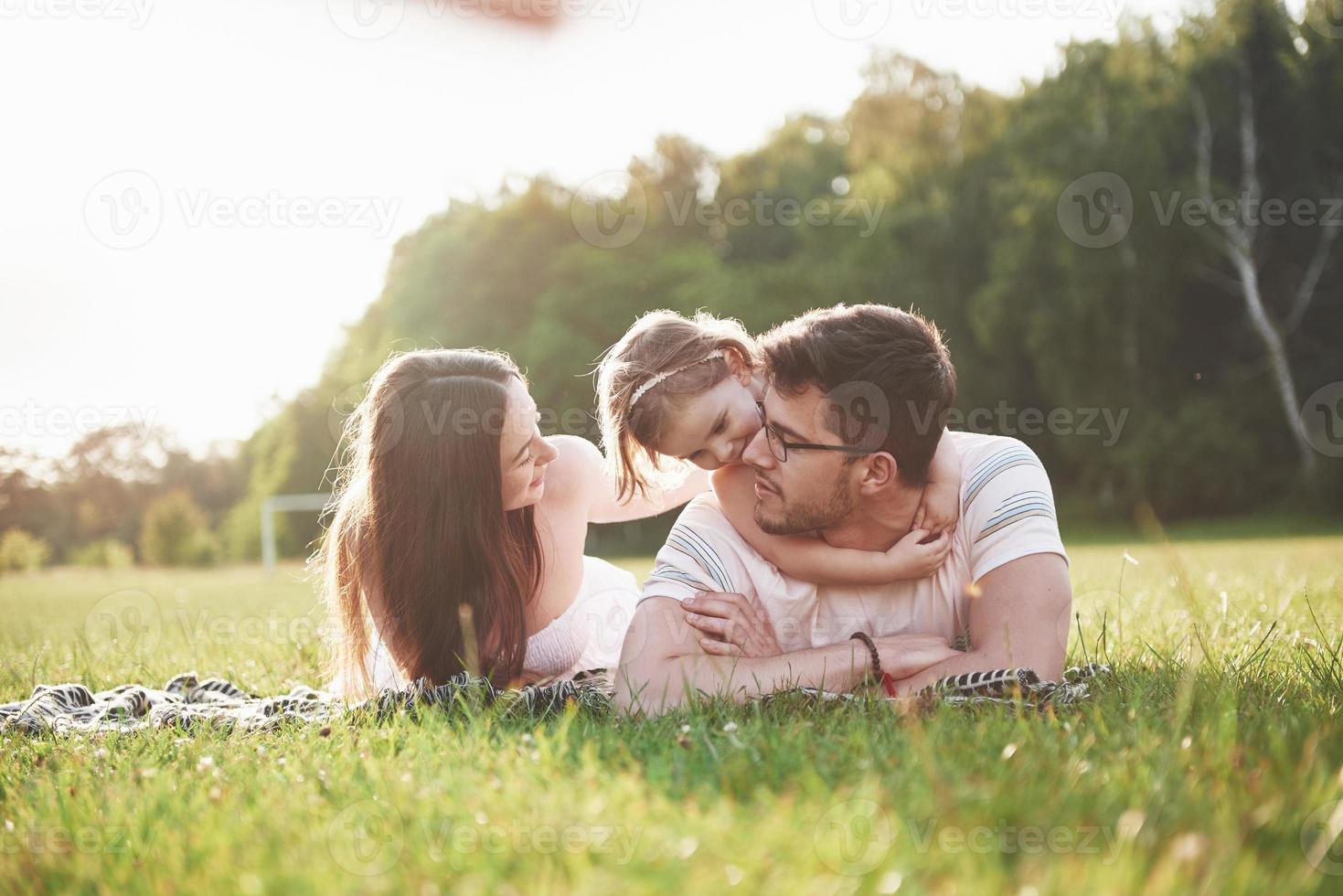 família feliz, pai de mãe e filha de bebê na natureza ao pôr do sol foto