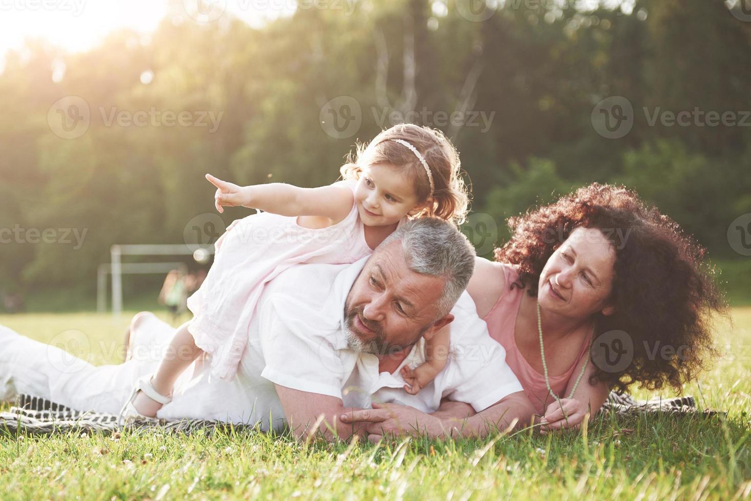 família feliz, pai de mãe e filha de bebê na natureza ao pôr do sol. foto