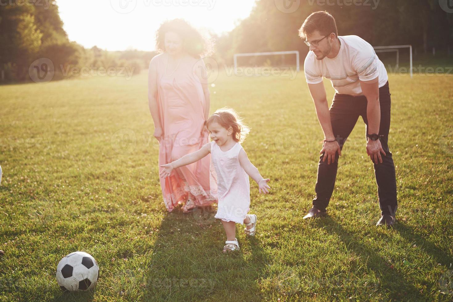 alegre família ativa se divertindo no campo num dia de verão. foto