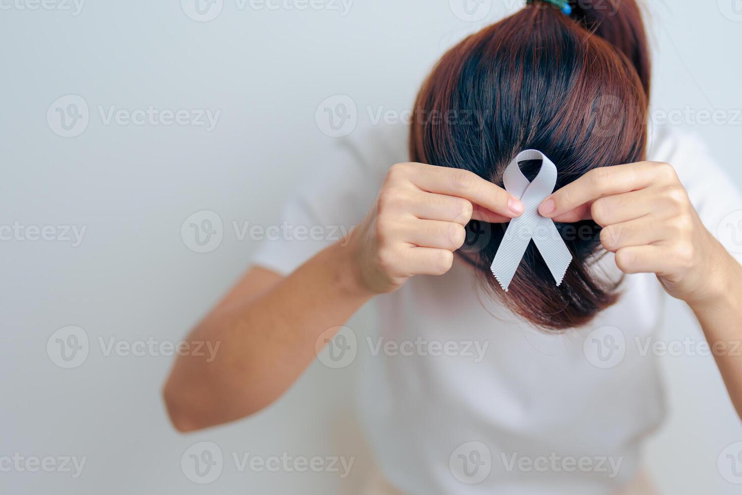 mulher tendo dor de cabeça com cinzento fita. cérebro Câncer consciência pode mês, mundo cérebro tumor dia, cérebro AVC, demência, Alzheimer, Parkinson e mundo mental saúde conceito foto