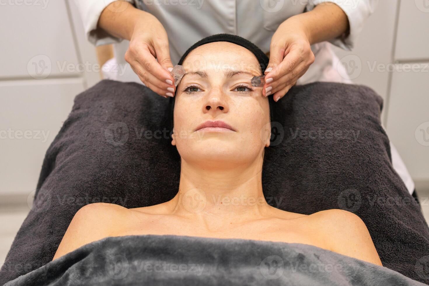 mulher recebendo facial pele tratamento a partir de colheita massagista dentro beleza Centro foto