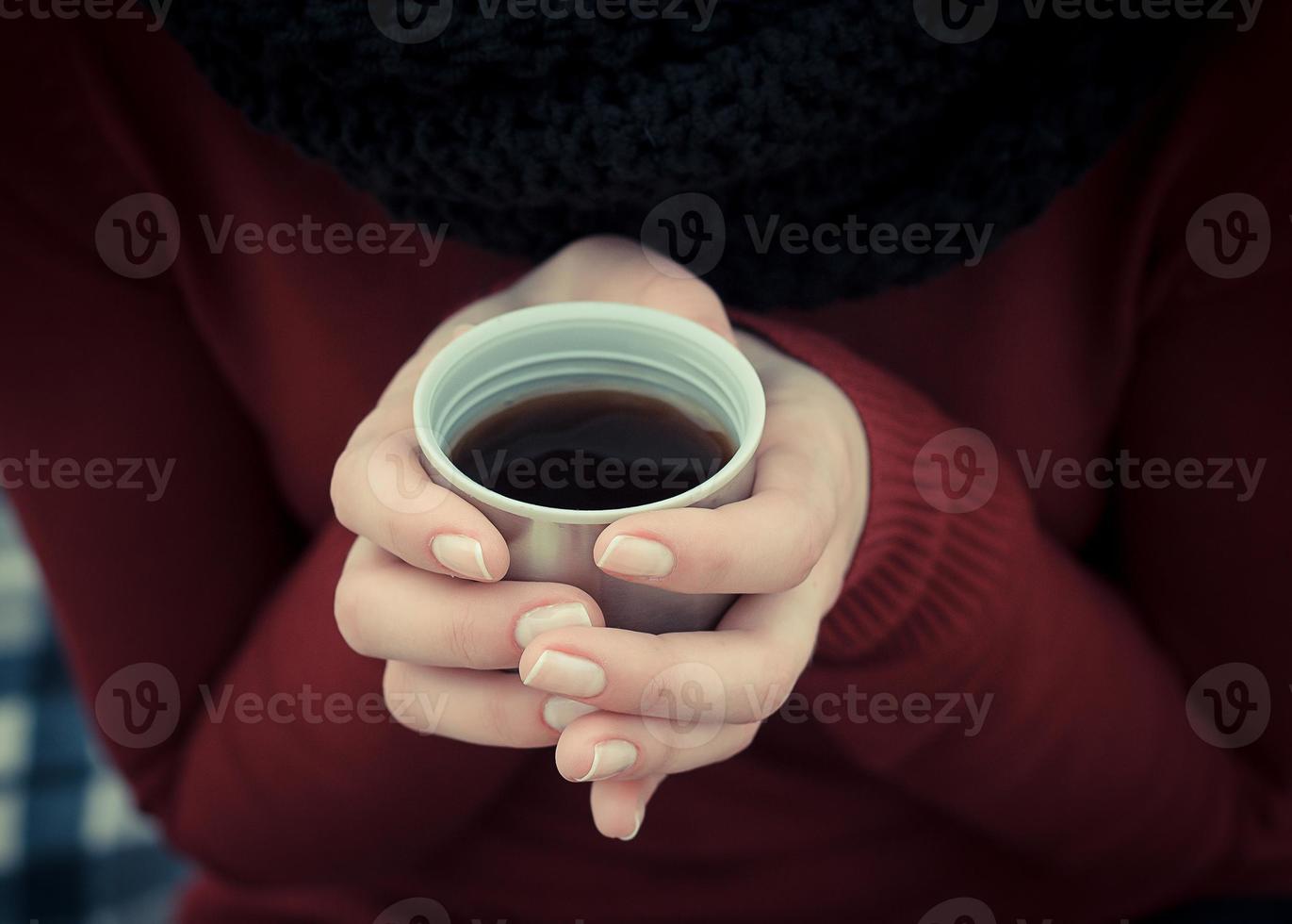 caneca de café na mão. mulher segura uma xícara de acampamento com bebida quente. foto