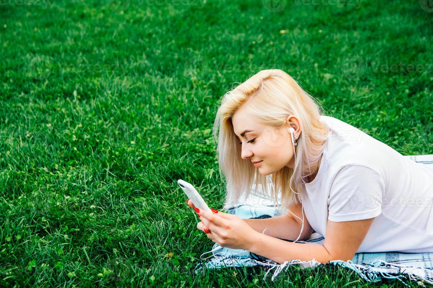 mulher com fones de ouvido e smartphone nas mãos ouvindo música foto