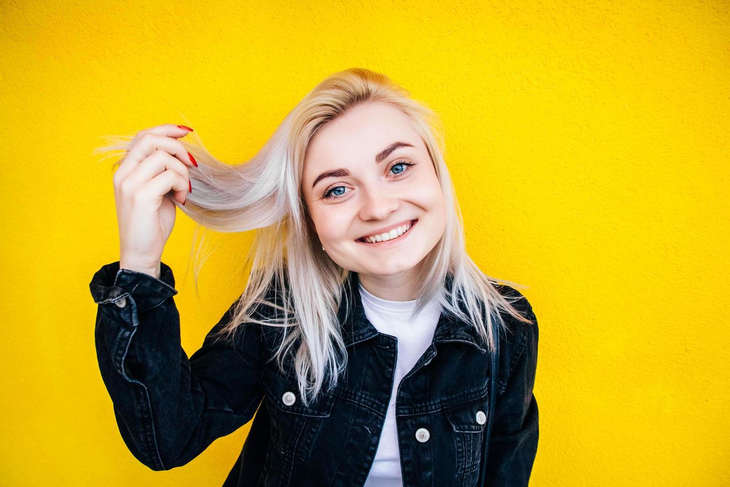 mulher sorrindo contra um fundo de parede amarela foto