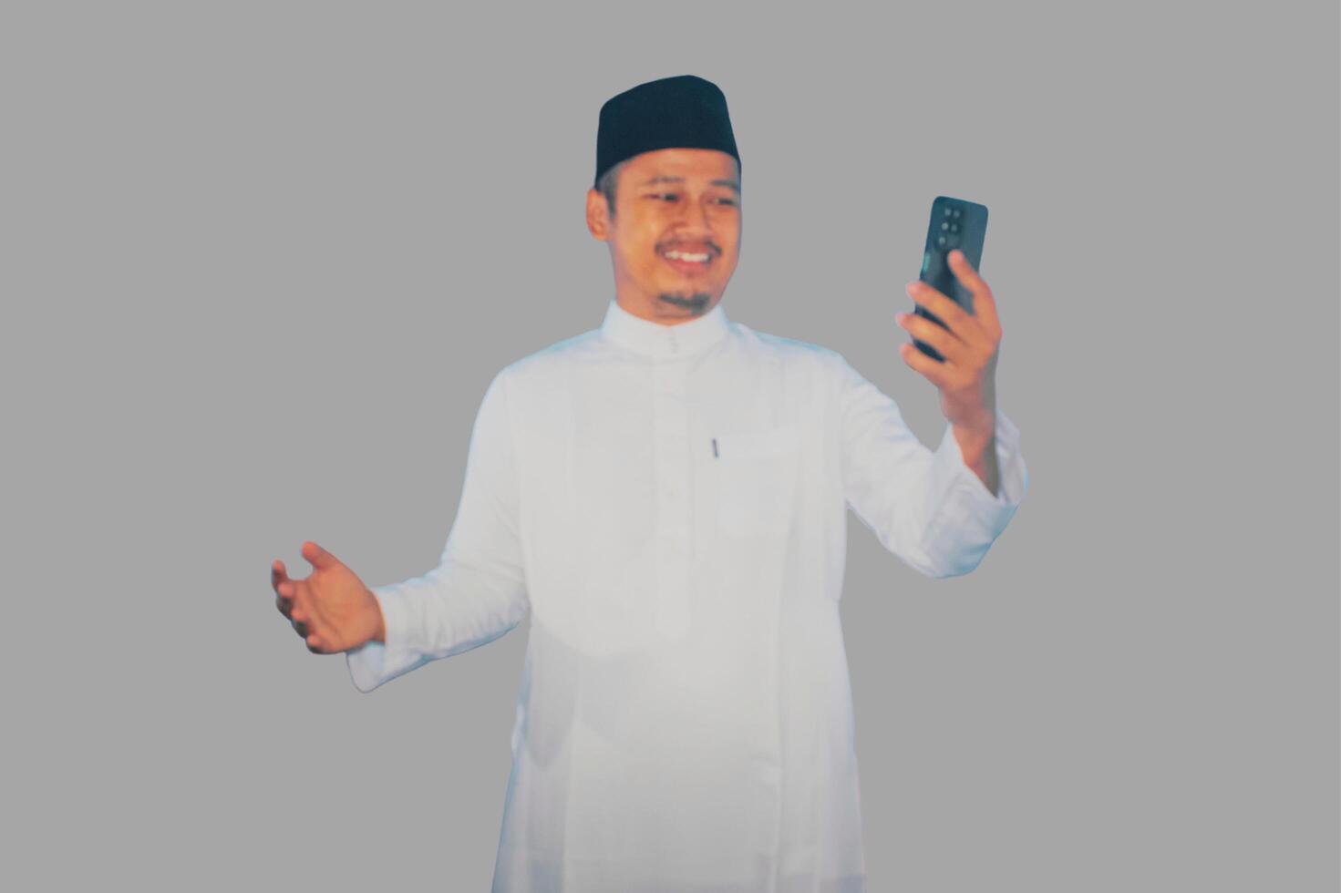 muçulmano ásia homem sorridente feliz enquanto olhando para dele Móvel telefone foto