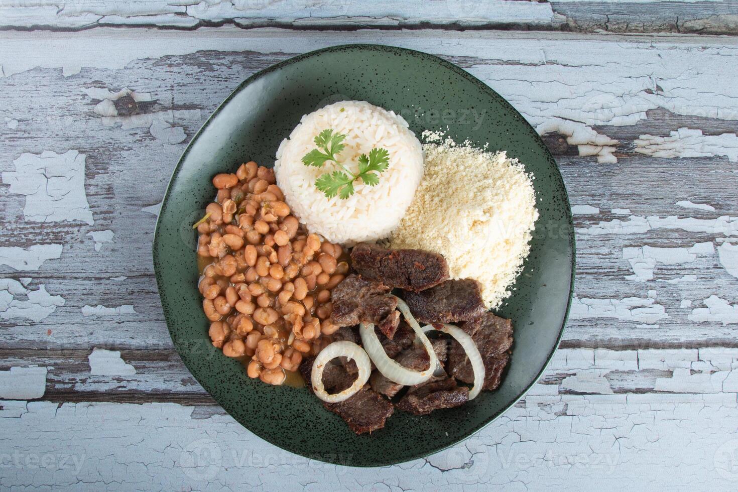 brasileiro Comida prato com feijões, arroz e carne foto