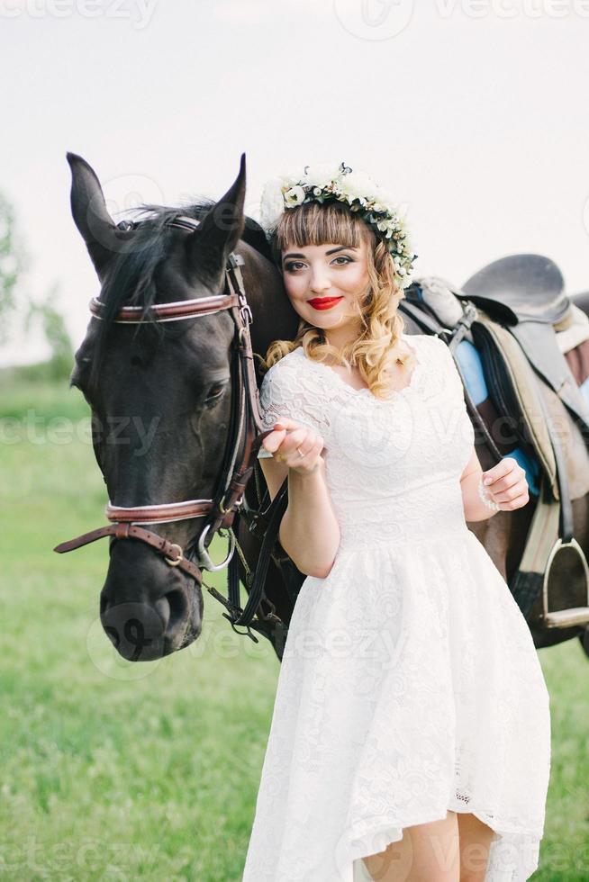 garota com lábios vermelhos perto de um cavalo preto foto