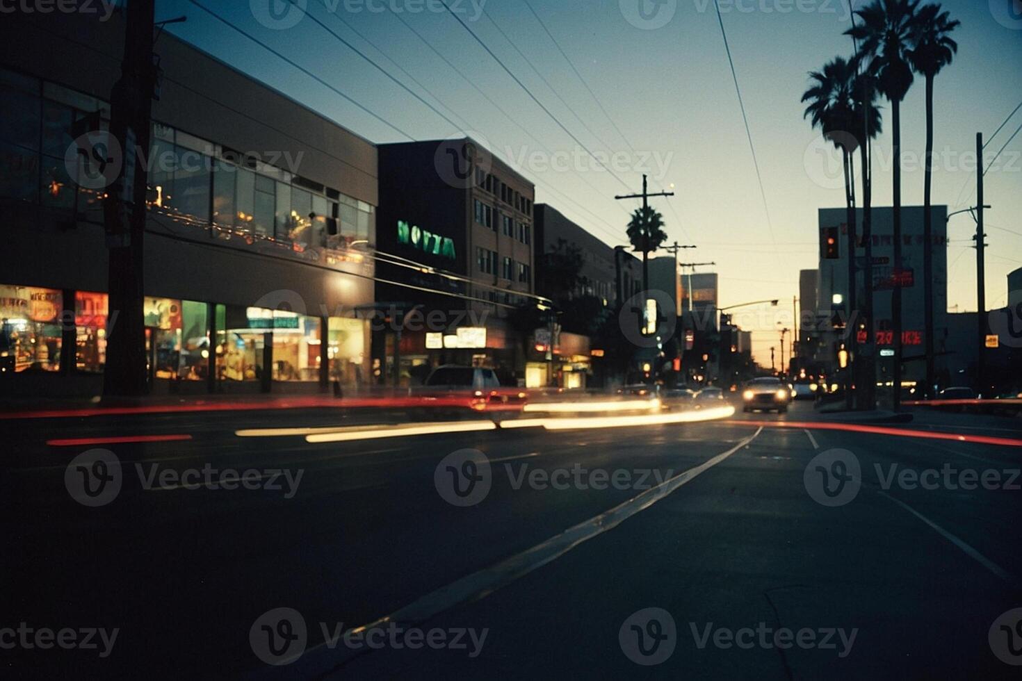 uma rua às crepúsculo com carros e Palma árvores foto