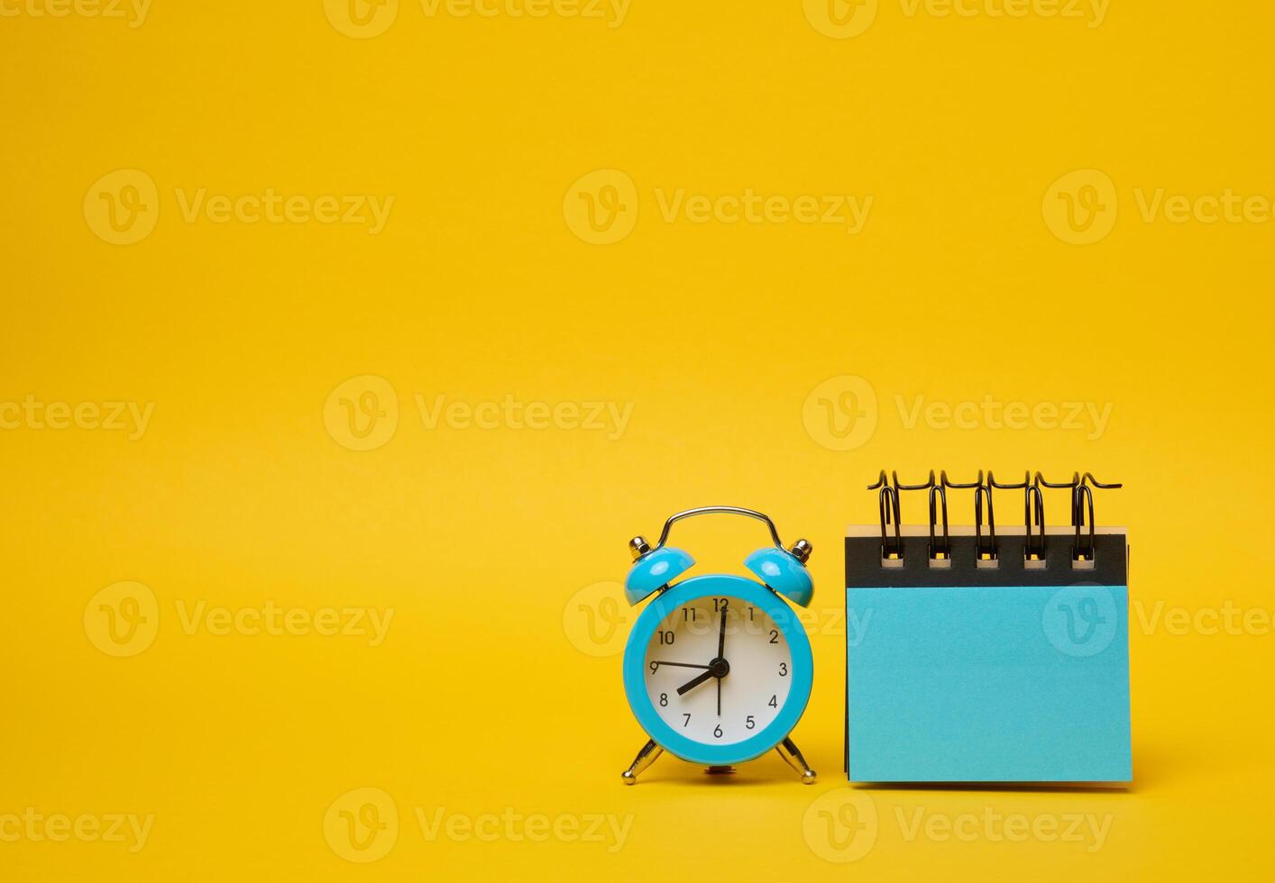 volta alarme relógio e azul adesivos em uma amarelo fundo foto