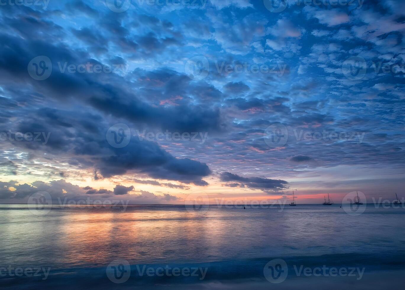 a Sol configuração sobre a oceano com pedras dentro a primeiro plano foto