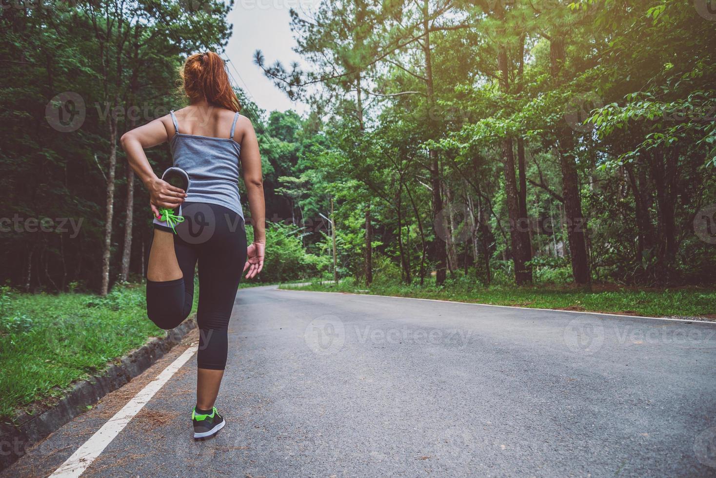 mulheres se exercitam na rua. Parque Natural. garota que está levantando as pernas para se exercitar. exercício, corrida. foto