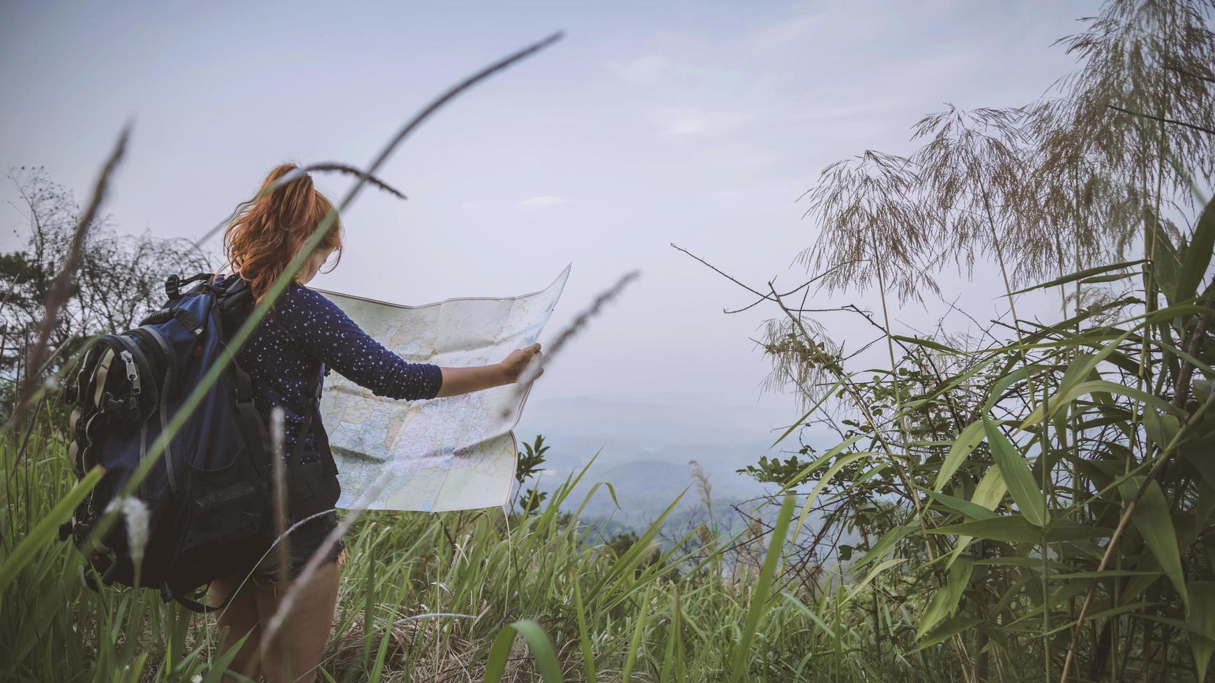 viagem de mulher. viajantes do sexo feminino viajam na natureza montanha no mapa de navegação foto