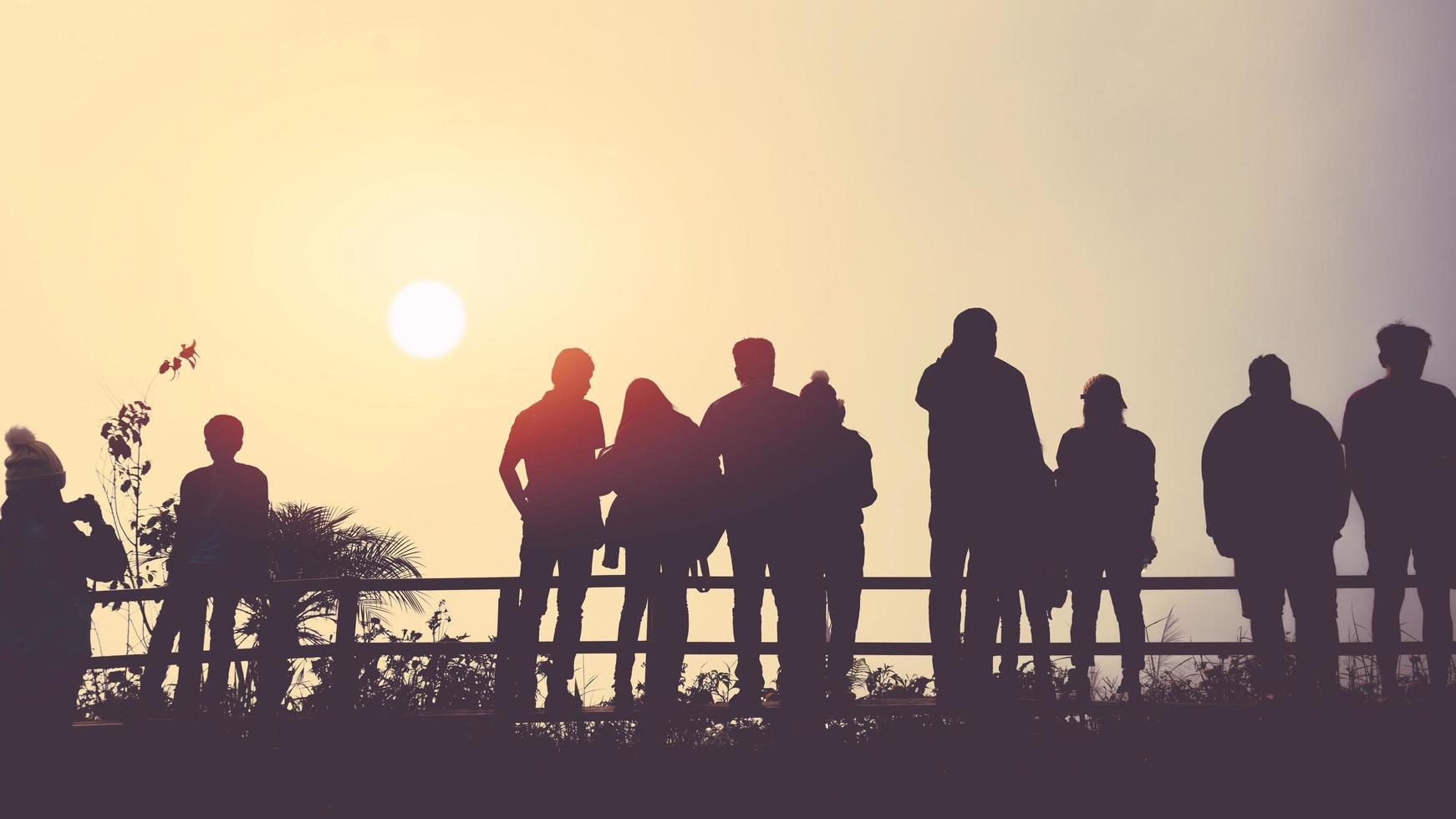 os asiáticos viajam relaxam no feriado. as pessoas ficam olhando para o sol pela manhã. levantar-se para o nascer do sol na montanha foto