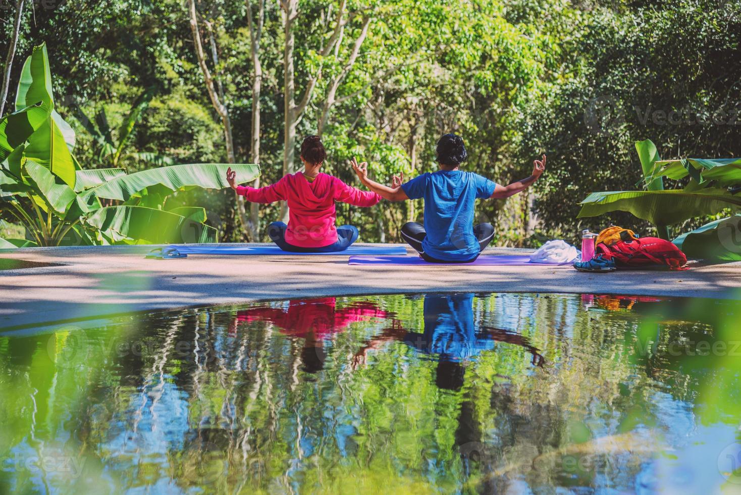 mulher asiática e homem asiático viajam pela natureza. viajar relaxar. conceito de postura de ioga, bons cuidados de saúde com posturas de ioga. exercícios ao ar livre relaxam a ioga. foto