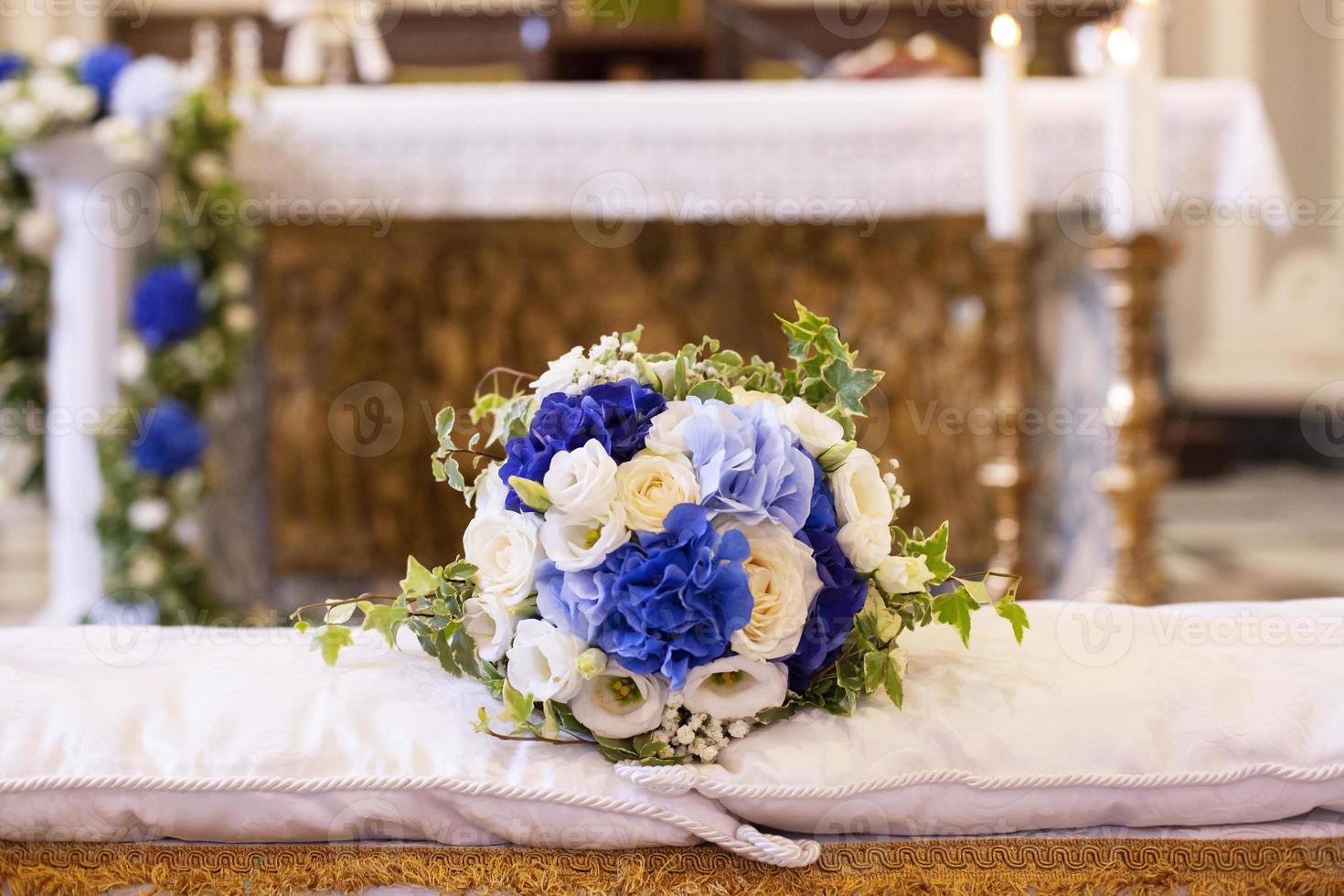 buquê de casamento sobre o banco dos noivos foto