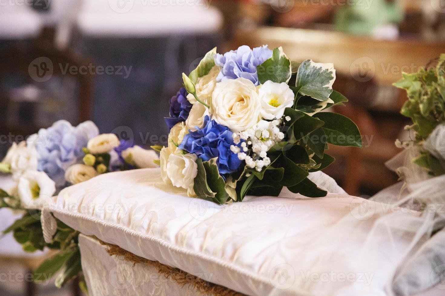 buquê de casamento sobre o banco dos noivos foto