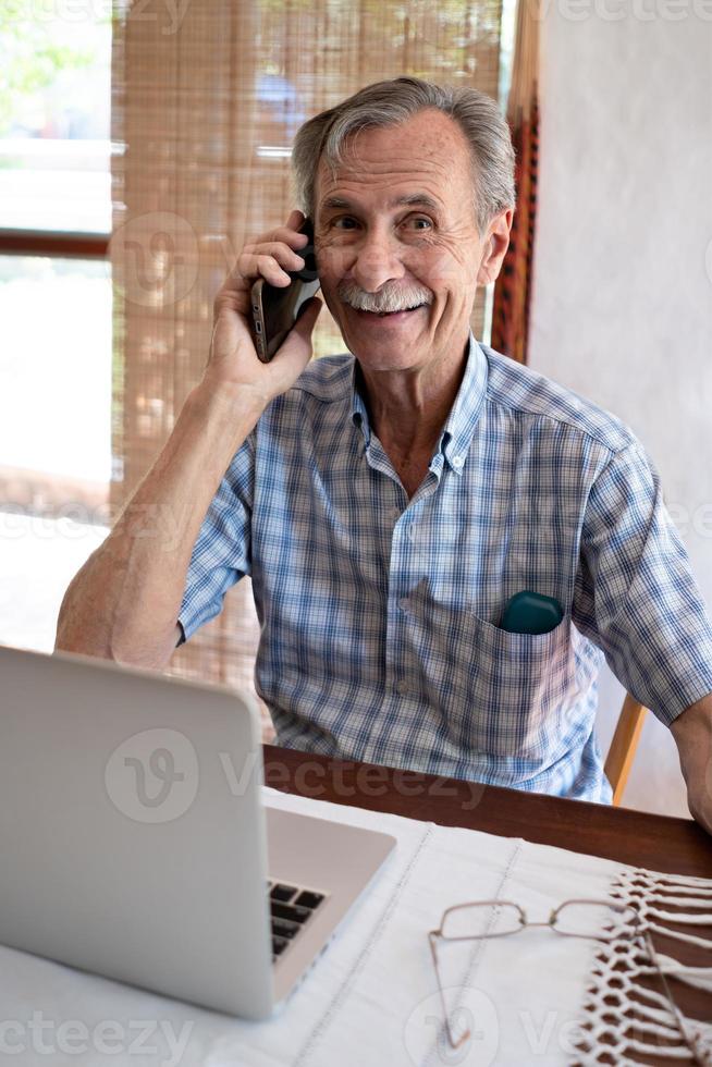 homem mais velho sorridente falando no celular foto