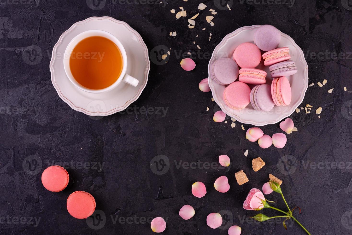 lindos macaroons saborosos cor de rosa em um fundo de concreto foto