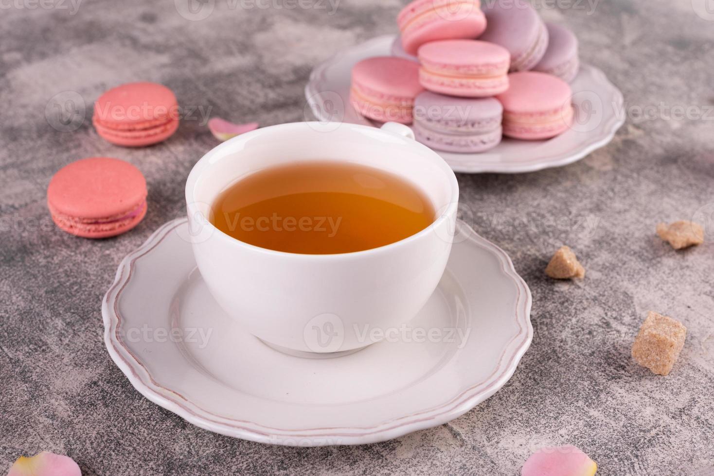 lindos macaroons saborosos cor de rosa em um fundo de concreto foto