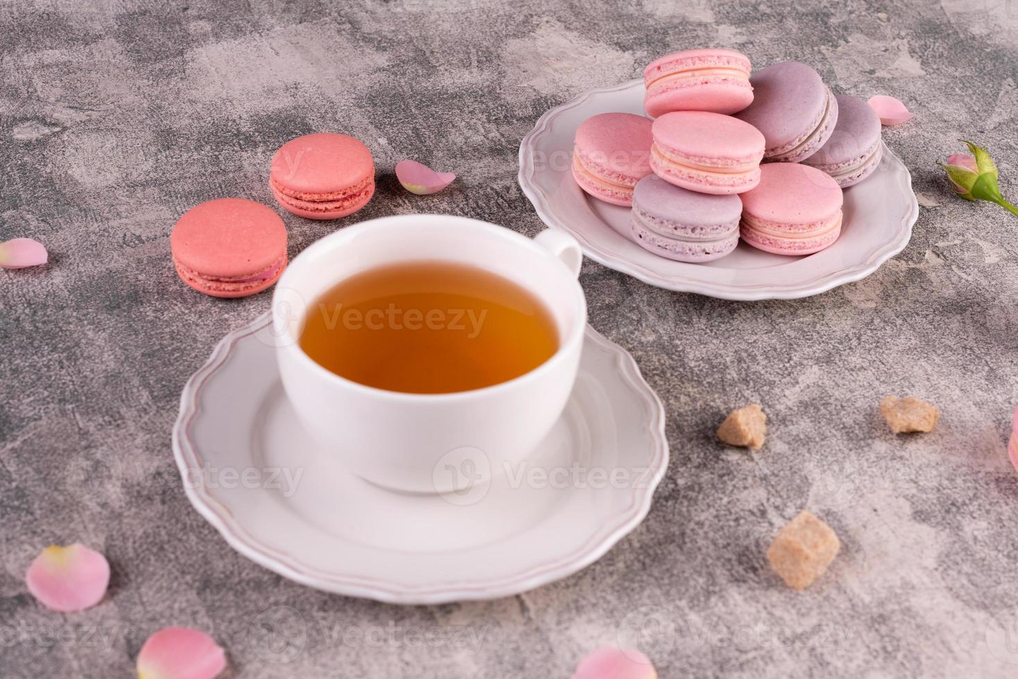 lindos macaroons saborosos cor de rosa em um fundo de concreto foto