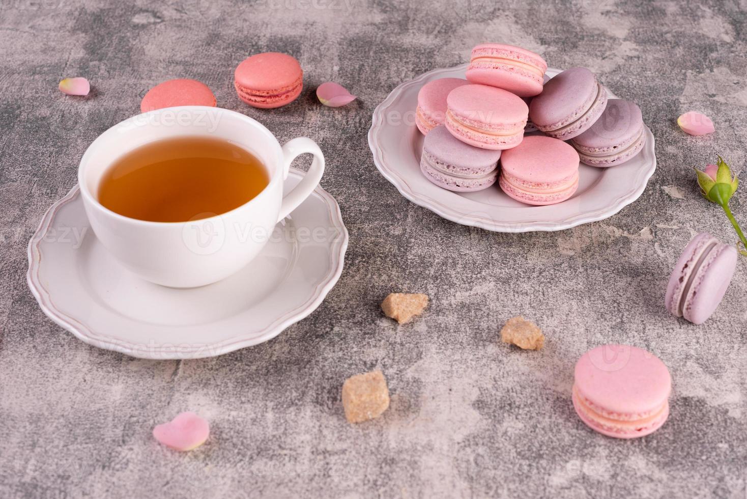 lindos macaroons saborosos cor de rosa em um fundo de concreto foto